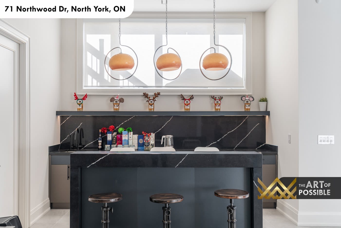 Basement wet bar with Nero Marquina marble island and amber globe pendants