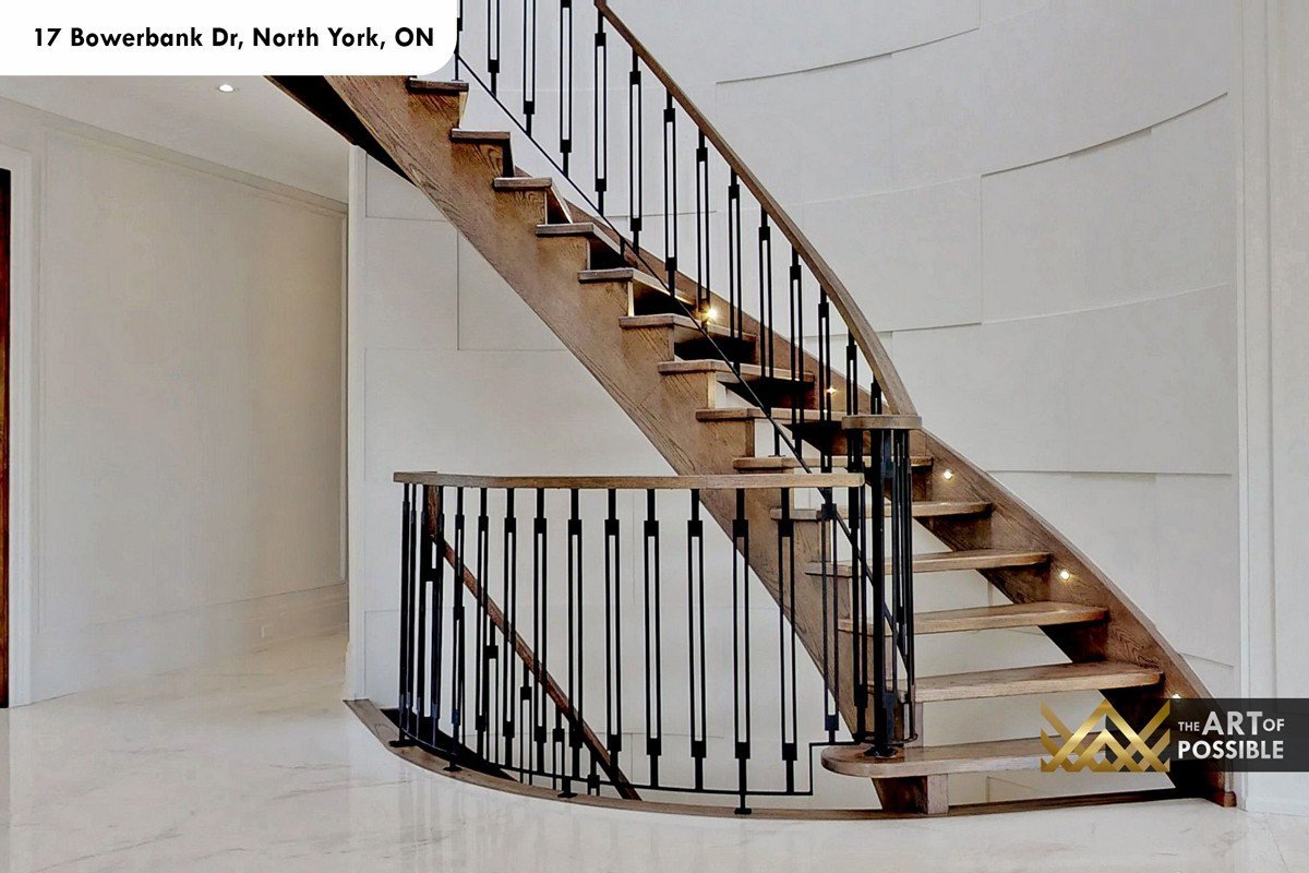 Close view of the curved staircase dark walnut treads and black iron square-post balusters