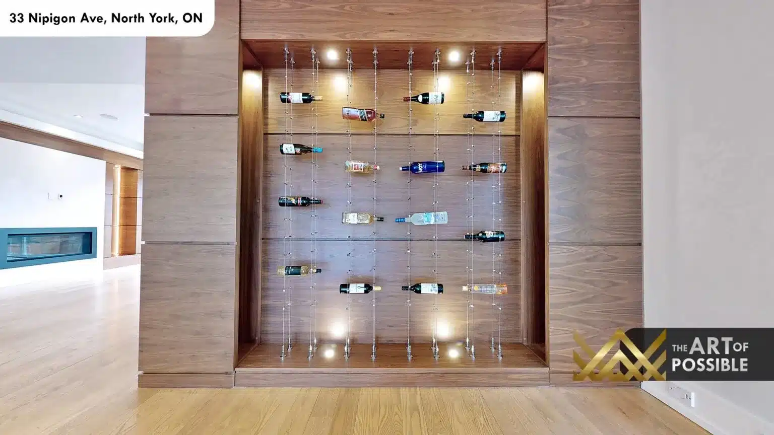 Close-up of illuminated walnut wine wall with cable-suspended bottle holders