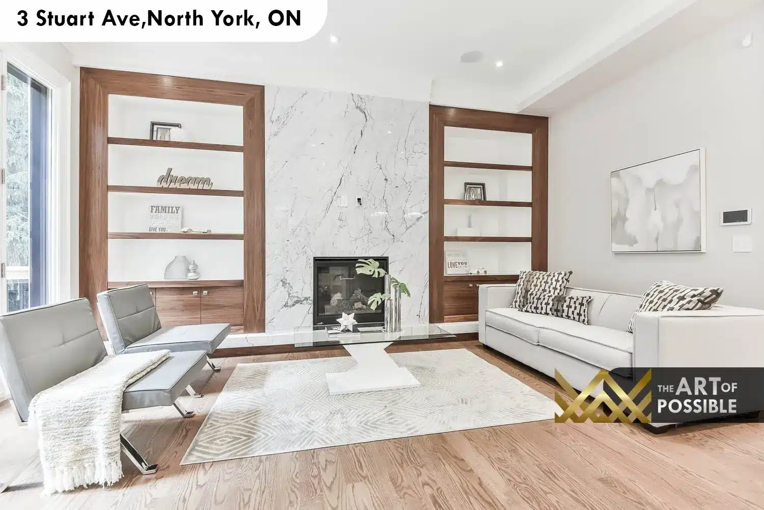 Family room with floor-to-ceiling veined marble fireplace surround flanked by walnut-framed built-in shelving