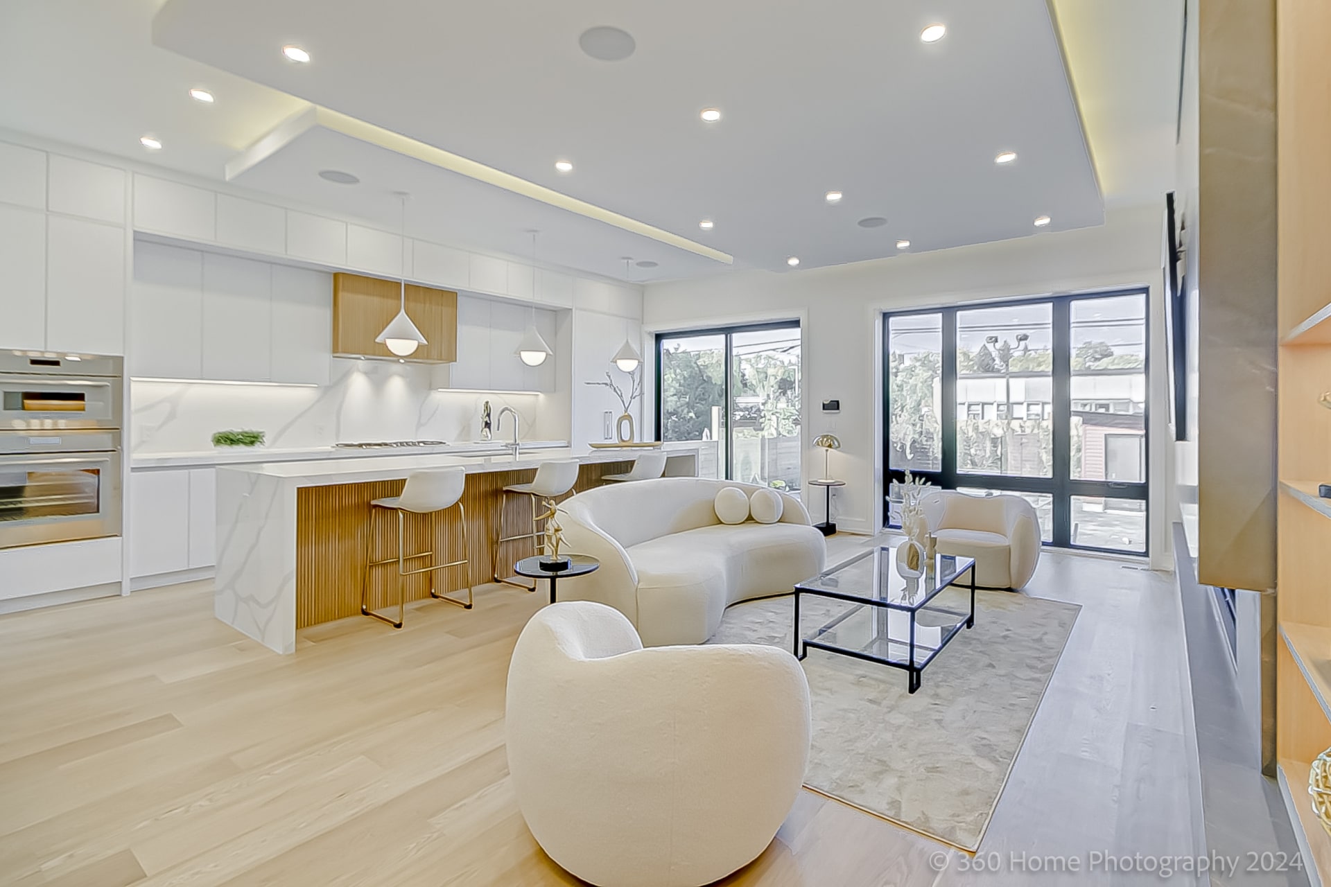 Open concept main floor with kitchen island, living seating and rear sliding glass doors at 100 Glenvale Blvd