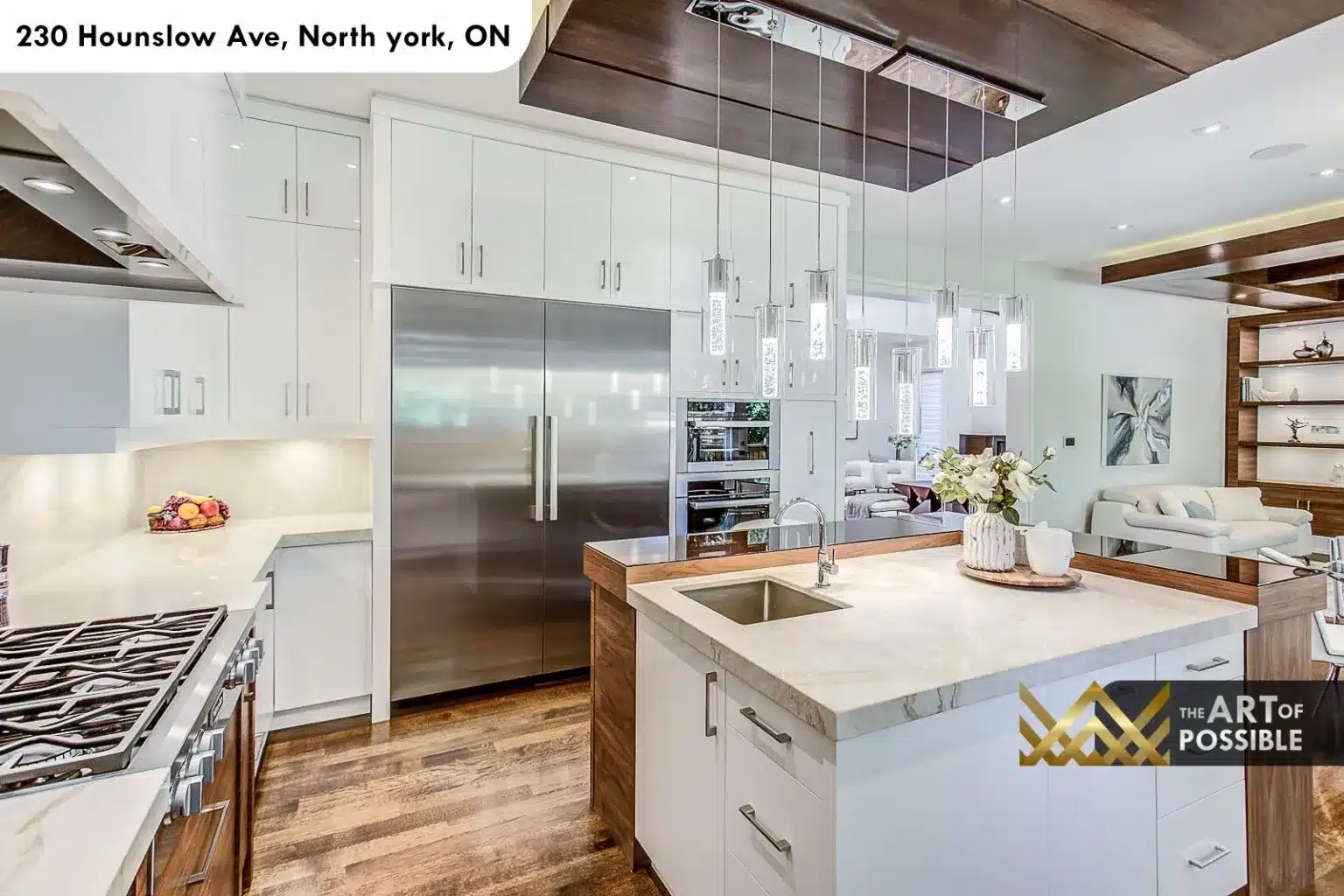Kitchen island with white quartz top and chrome pendants at 230 Hounslow Ave