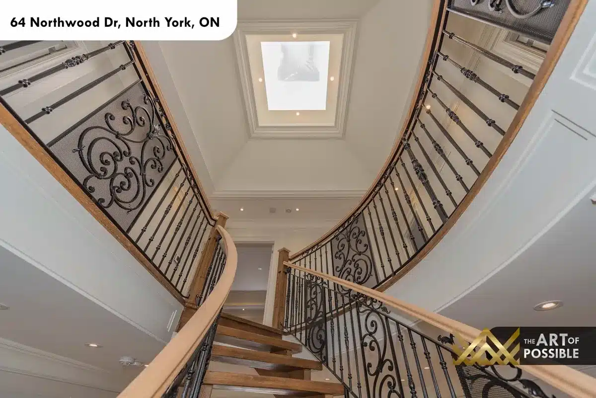 Looking up the curved staircase toward the square skylight